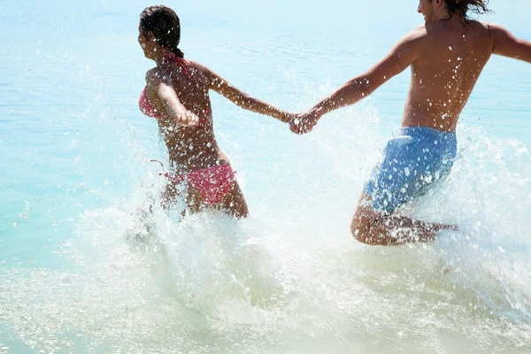 Pareja enamorada corre hacia el mar —  Fotos de Stock