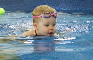Bebek havuzda zevkle yüzüyor.