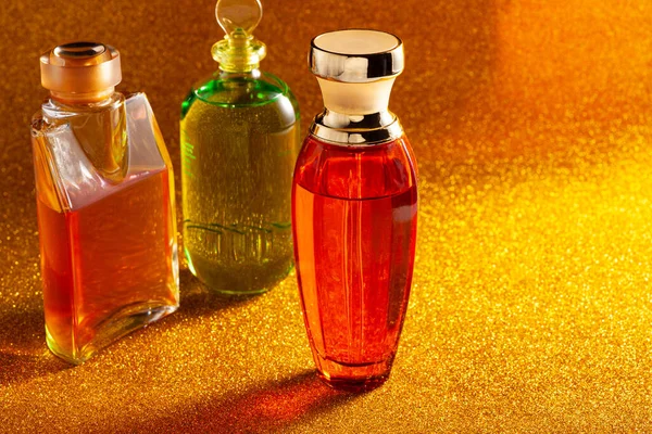 Pomerančové Zelené Lahvičky Parfémů Zlatě Třpytivém Povrchu — Stock fotografie