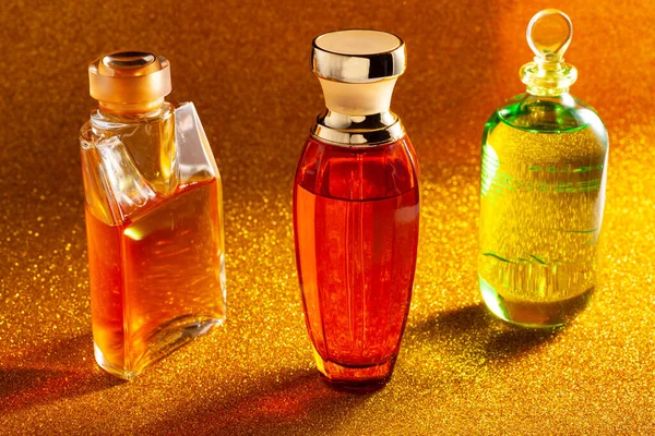Frascos Perfume Naranja Verde Sobre Una Superficie Dorada Brillante —  Fotos de Stock