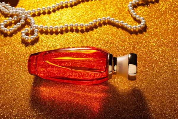 Frasco Perfume Naranja Collar Perlas Superficie Brillante Oro —  Fotos de Stock