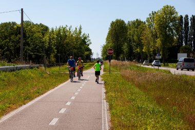 Aquileia, İtalya - Haziran 02: Bisikletçiler Haziran 2021 'de kırsal yolda birlikte koşuyorlar