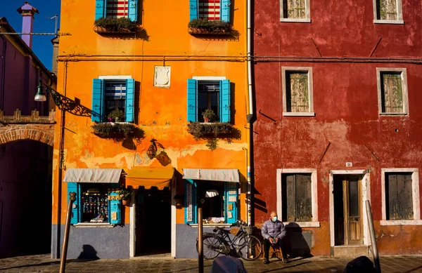 2022年1月6日イタリア ブラノ島のカラフルな家の裏側で 自転車の隣の家の外に座っているイタリアの高齢者 — ストック写真