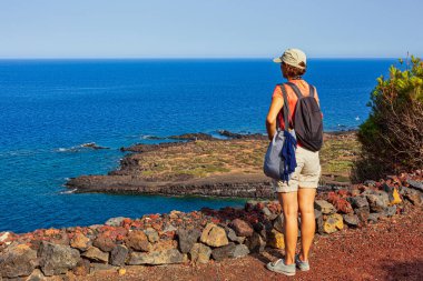 Yanardağın tepesinden denize bakan kadının adı Monte Nero, Linosa. Sicilya. İtalya