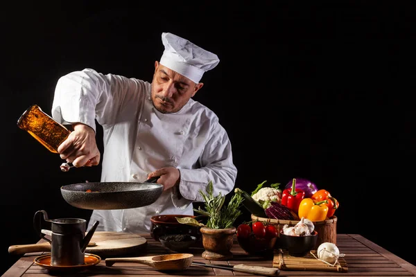 Chef Masculino Uniforme Blanco Vertiendo Vinagre Sartén Con Verduras Antes —  Fotos de Stock