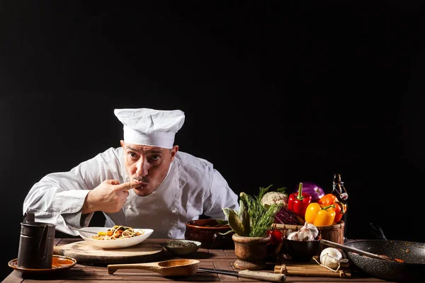 Chef Masculino Uniforme Branco Preparando Espaguete Com Legumes Entretanto Lambendo — Fotografia de Stock
