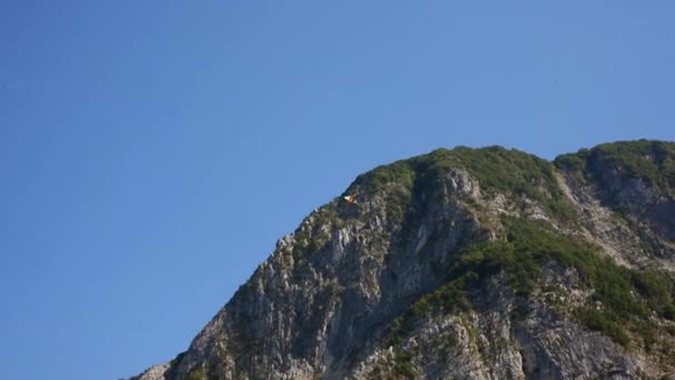 凧は青い雲のない空に高く舞う美しい山の峰の背景 — ストック動画