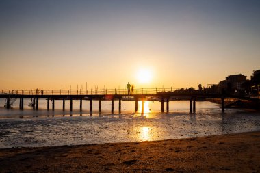 High quality photo of a pier at sundown. Wooded bridge seaside with Sunset, Strunjan. Slovenia