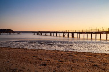 High quality photo of a pier at sundown. Wooded bridge seaside with Sunset, Strunjan. Slovenia