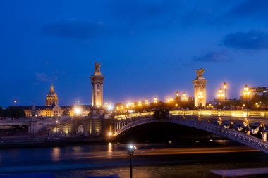 Pont Alexandre III Bridge and illuminated lamp posts at sunset with view of the Invalides. 7th Arrondissement, Paris, France