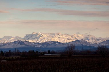 View of the Italian countryside with alp mountains on the background in the winter season