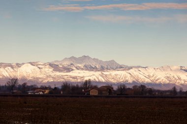 View of the Italian countryside with alp mountains on the background in the winter season
