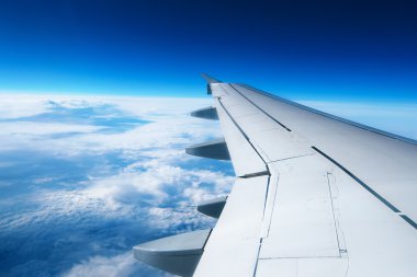 Bulutların üzerinde uçan bir uçağın kanadı