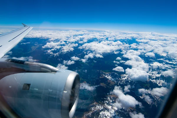 View from the airplane window at the snow-covered mountain peaks — Stock Photo, Image