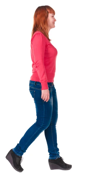 Bakifrån Walking glad rödhårig kvinna i jeans — Stockfoto