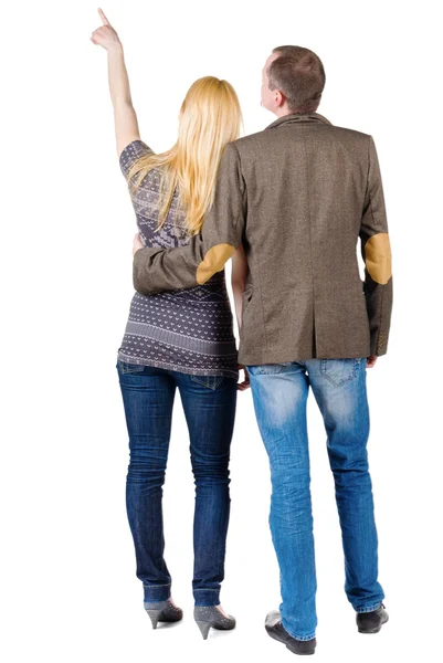 Back view of young couple pointing at wall. — Stock Photo, Image