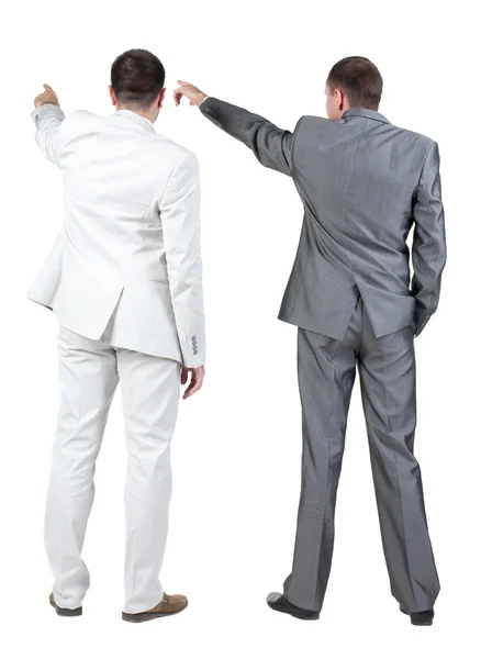 Back view of two businessman pointing at wall. rear view. — Stock Photo, Image