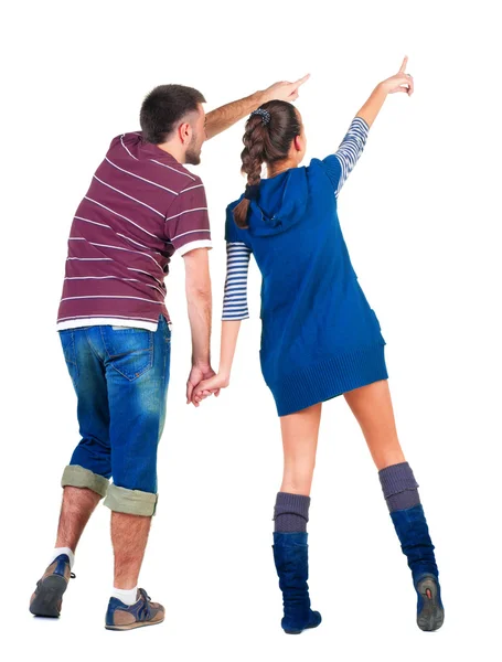 Back view of young couple pointing at white wall — Stock Photo, Image