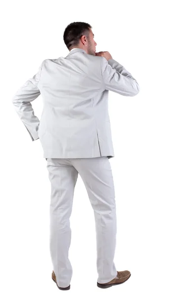 Back view of thinking young business man in white suit. Royalty Free Stock Images
