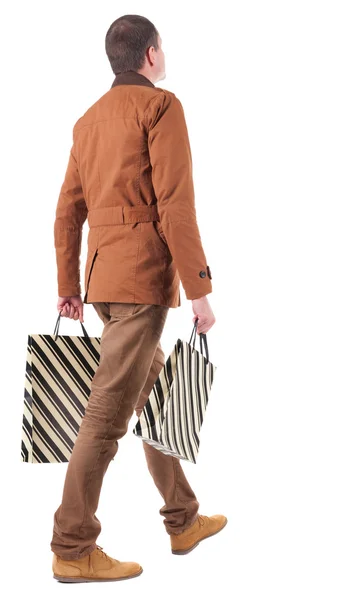 Πίσω όψη του να πηγαίνει όμορφος άντρας με τσάντες για ψώνια. — Φωτογραφία Αρχείου