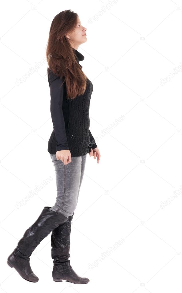 Back view of going woman in jeans and sweater