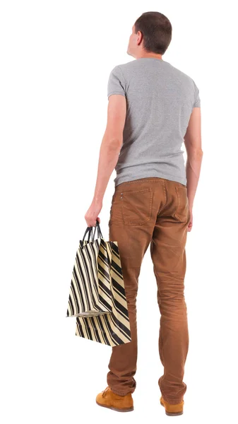 買い物袋を持つハンサムな男の背面図 — ストック写真