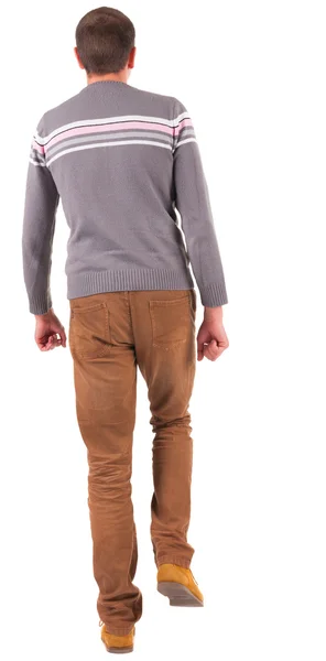 Rückansicht des laufenden Mann in Pulli und braune jeans. — Stockfoto