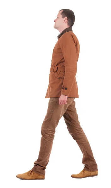 Achteraanzicht van gaan knappe man in jeans en jas. — Stockfoto