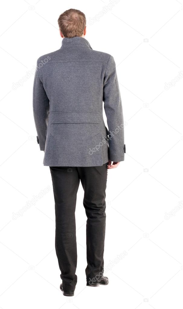 Back view of going handsome business man in coat