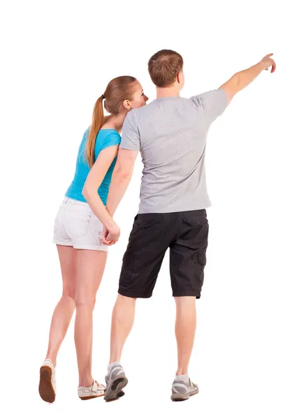 Back view of young couple pointing at wall — Stock Photo, Image