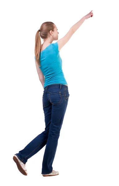 Vista posterior de mujer camina en jeans y camisa señalando —  Fotos de Stock