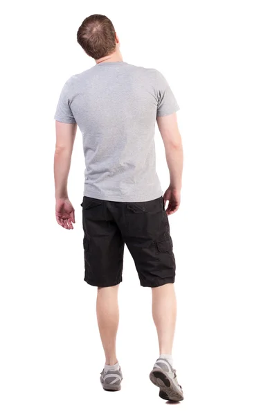 Back view of walking handsome man in shorts and sneakers — Stock Photo, Image