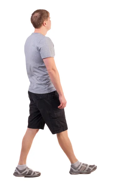Vista posterior de caminar hombre guapo en pantalones cortos y zapatillas —  Fotos de Stock
