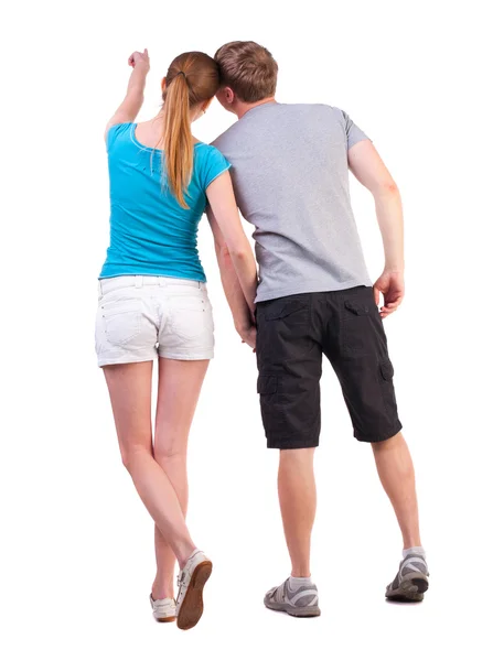 Visão traseira do jovem casal apontando para a parede — Fotografia de Stock