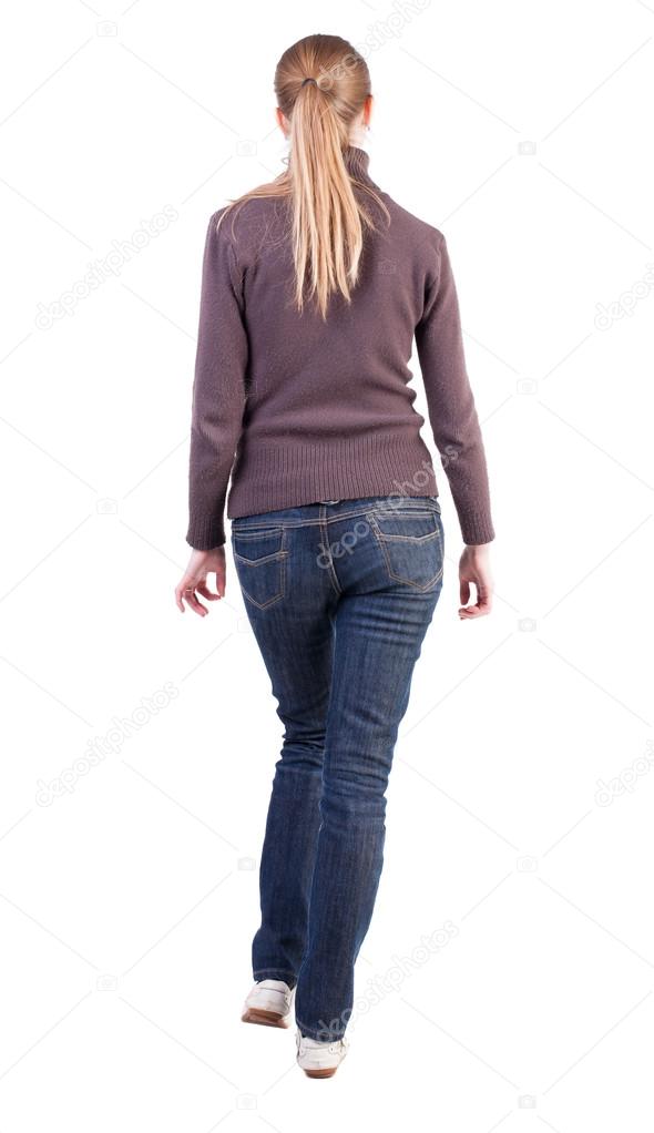 back view of walking woman in sweater