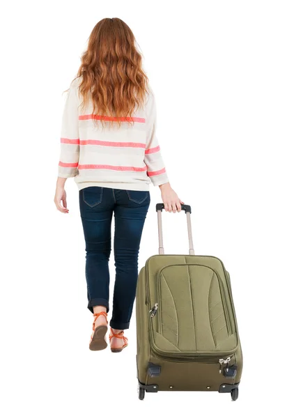 Назад точка зрения идущей женщины с чемоданом. — стоковое фото