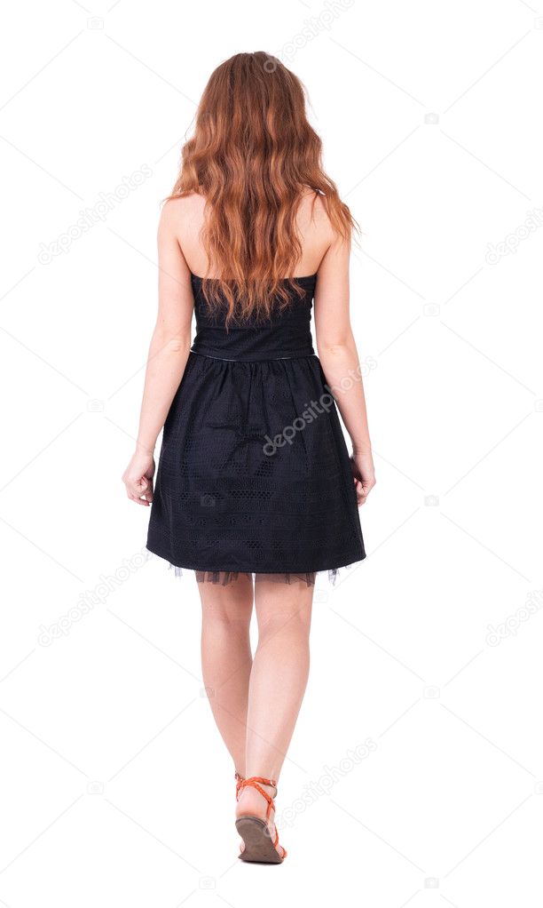 back view of walking young beautiful redhead woman