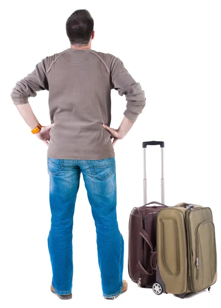 Back view of traveling man with suitcase looking up. – stockfoto