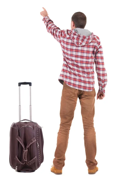 Back view of traveling man with suitcase pointing. Rear view peo — Stock Photo, Image