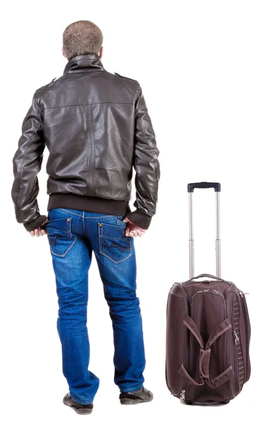 Back view of traveling man with suitcase looking up. – stockfoto