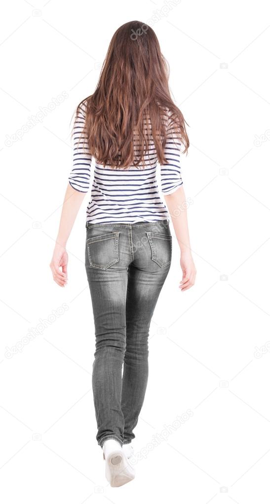 back view of walking woman in jeans .