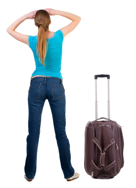 Back view of blonde woman with suitcase looking up. — Stock Photo, Image