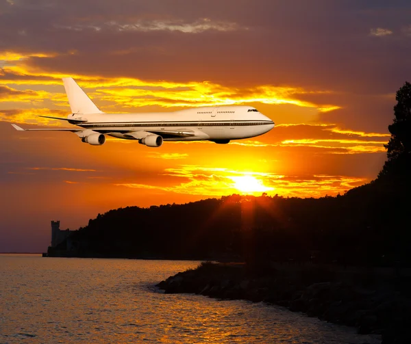 Passagerare flygplan i moln på solnedgången eller dawn. — Stockfoto