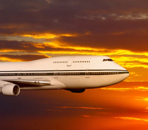 Αεροπλάνο επιβατών στα σύννεφα στο ηλιοβασίλεμα ή την αυγή. — Φωτογραφία Αρχείου
