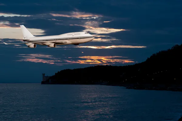 Passagierflugzeug in den Wolken bei Sonnenuntergang oder dawn. — Stockfoto