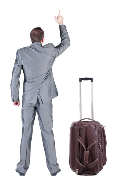Back view of traveling business man with suitcase pointing. — Stock Photo, Image