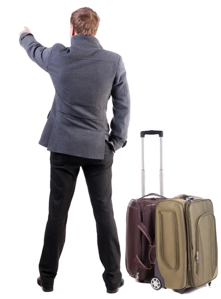 Back view of traveling business man with suitcase pointing. — Stock Photo, Image