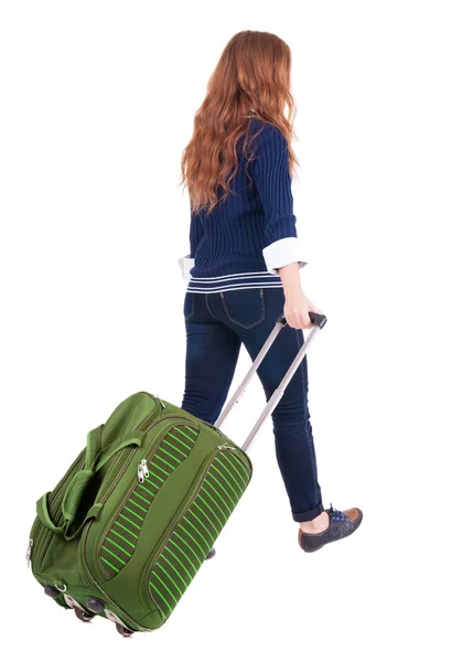 スーツケースを持つ女性の歩行の背面図 — ストック写真