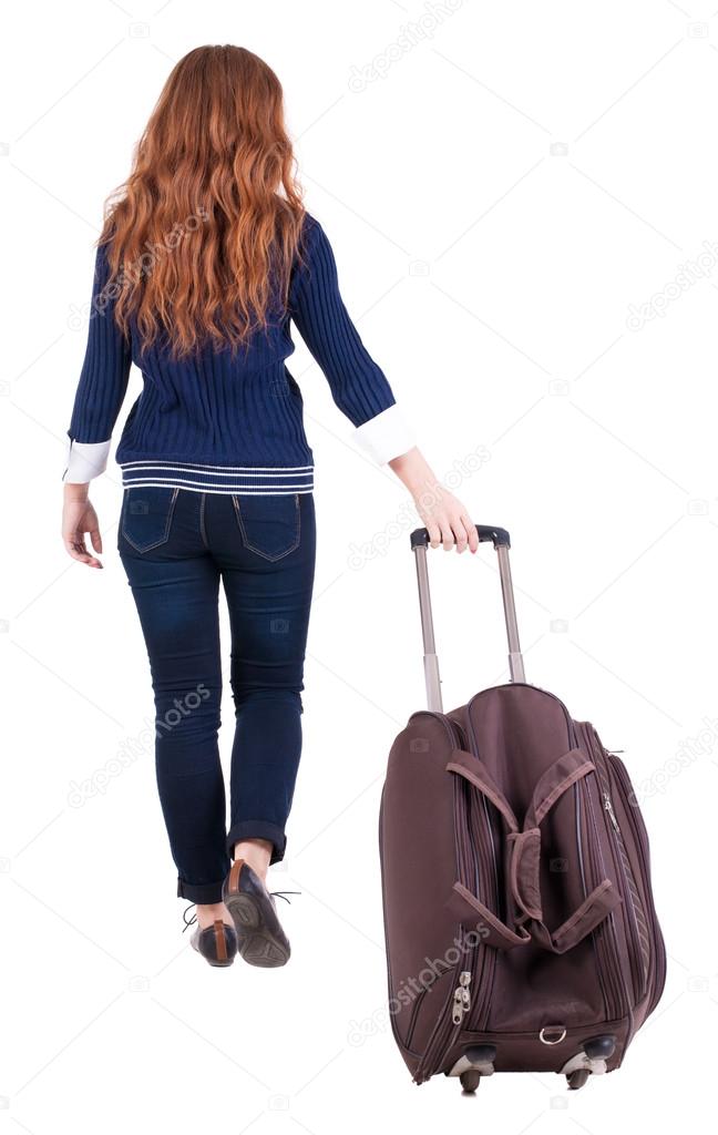 back view of walking woman with suitcase
