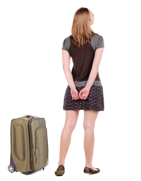 Back view of traveling blonde woman in dress with suitcase looki — Stock Photo, Image